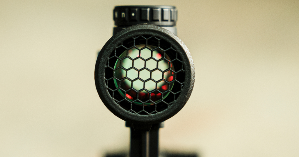 A close up of a hex cap over a rifle scope.