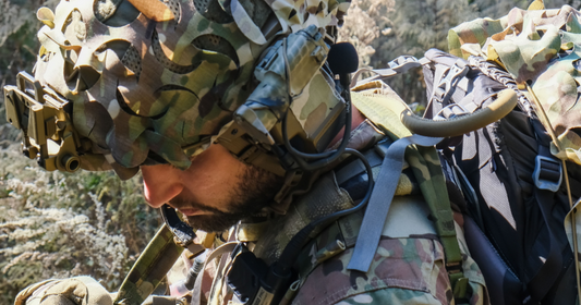 Solider wearing tactical gear and helmet scrim.