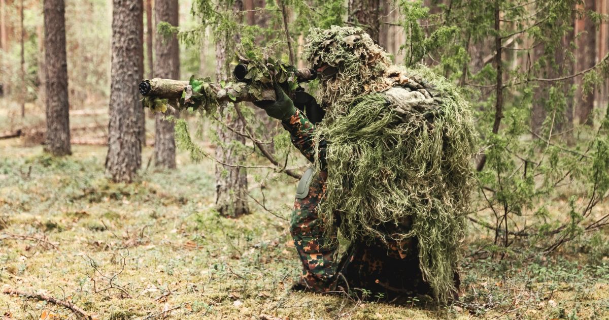 A special forces shooter using camo to blend into the environment.