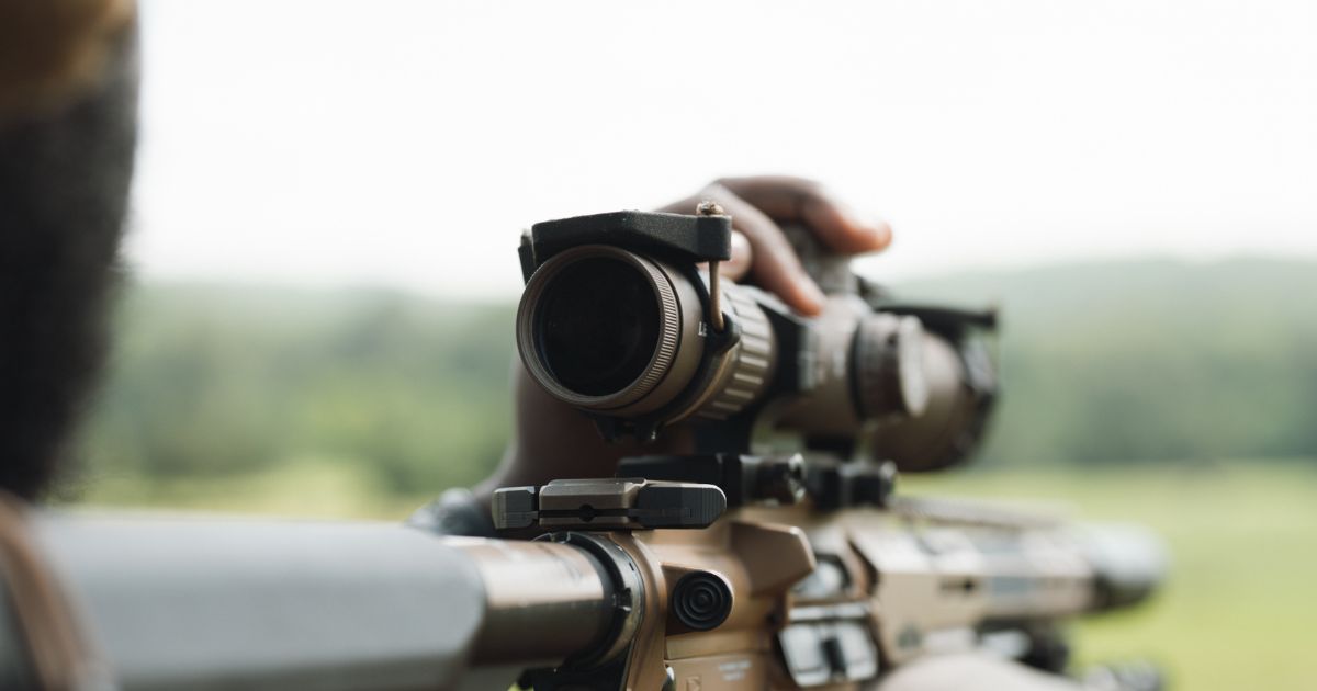 A shooter using his optic to line up a shot.