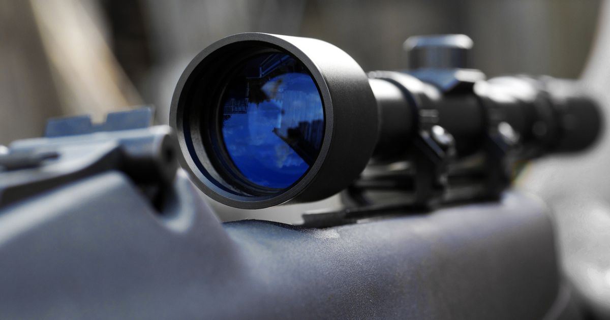 A closeup of a scope on a rifle.
