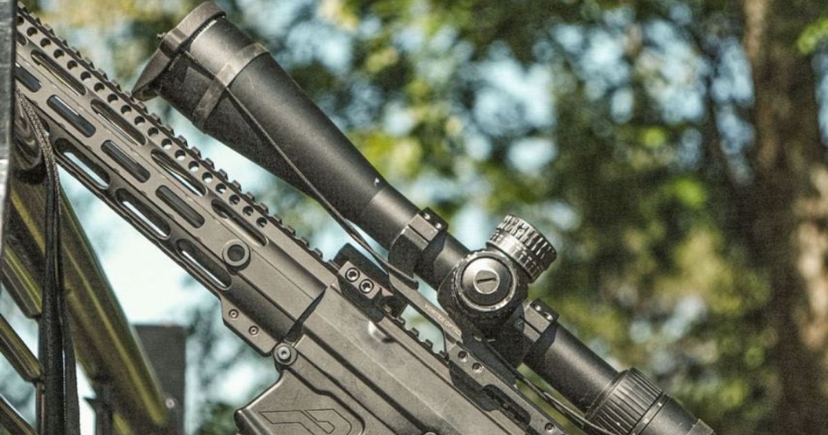 A long-range shooting rifle with a scope and a One Hundred Concept's Scope Cap.